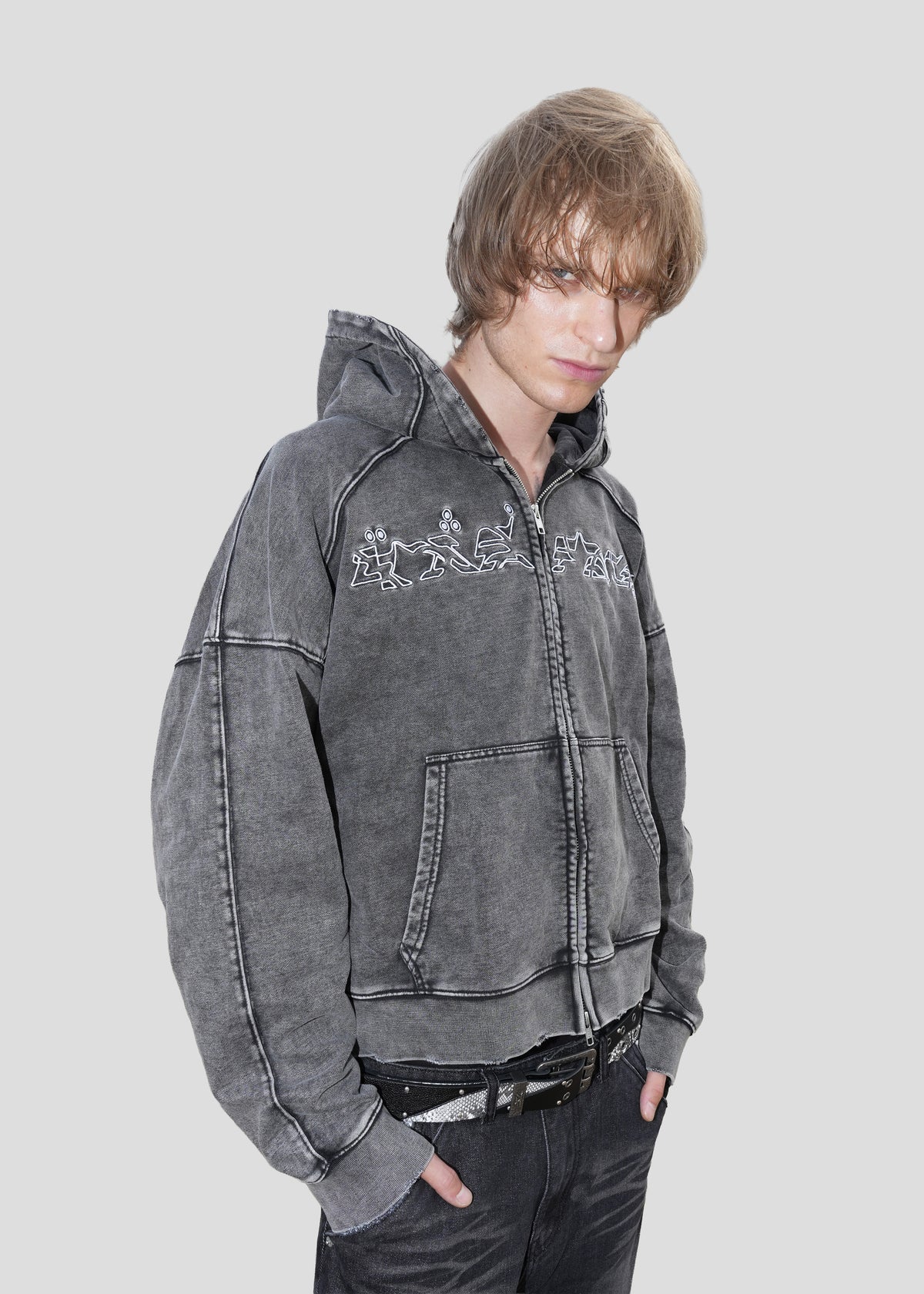 Model wearing the ONEFATE Washed Zip-Hoodie at a three-quarter angle with hands in the kangaroo pocket