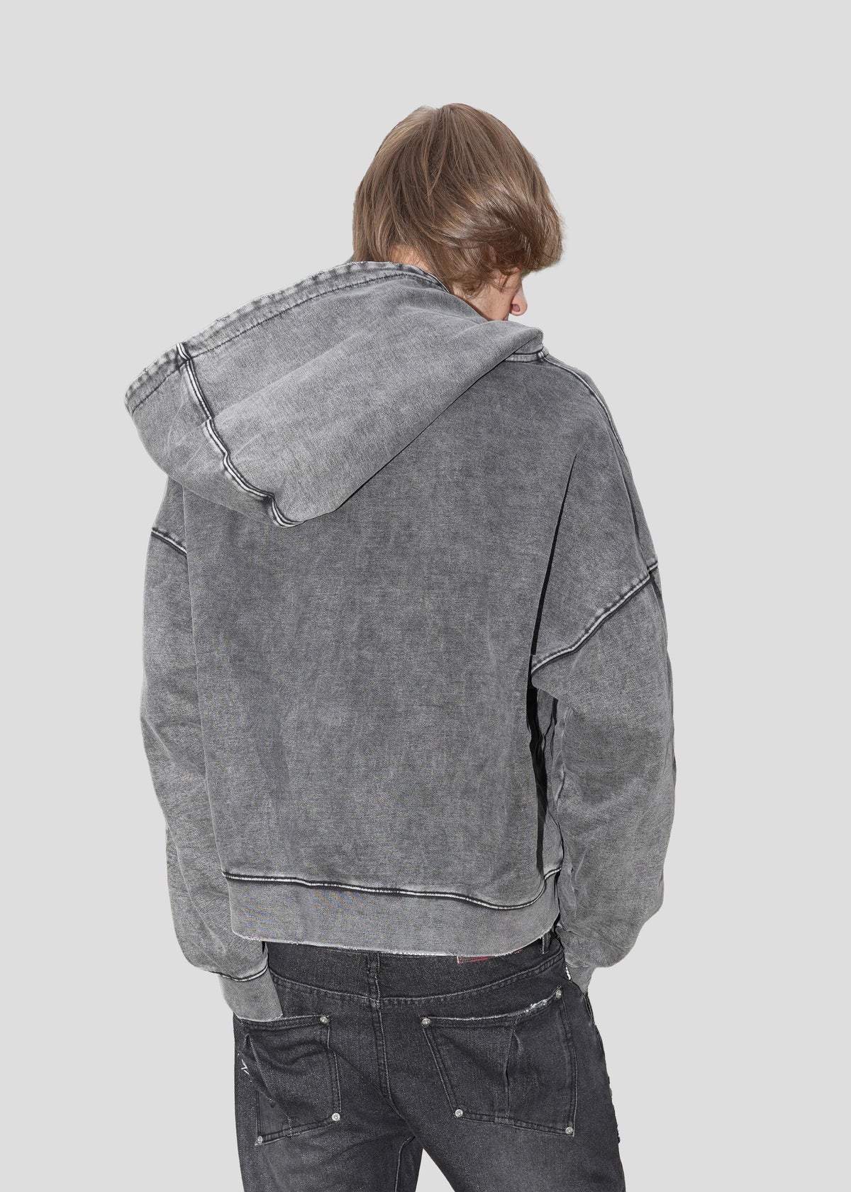 Model seen from behind wearing the ONEFATE Washed Zip-Hoodie with the hood down