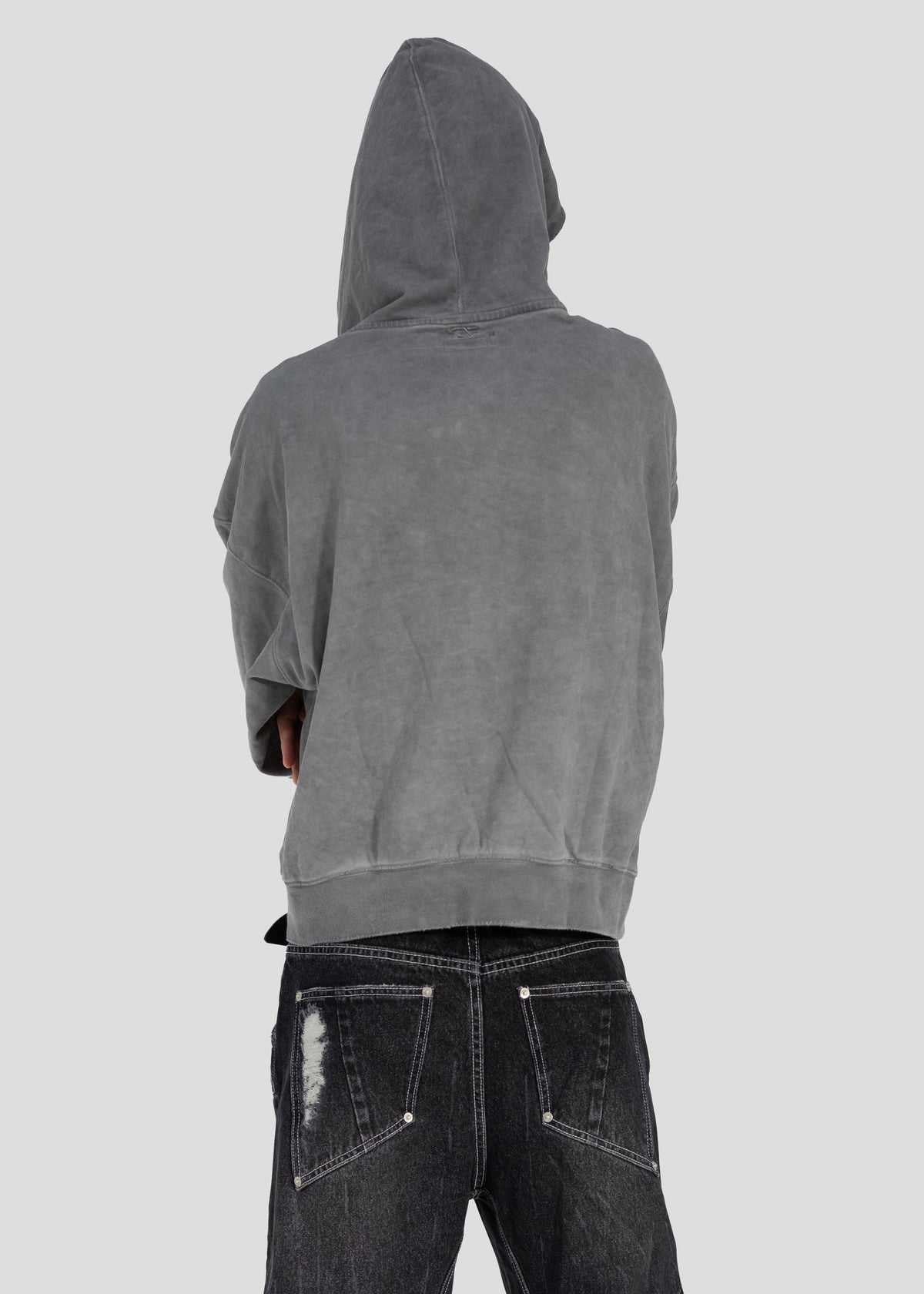 Model seen from behind wearing the ONEFATE Dyed Hoodie with the hood up