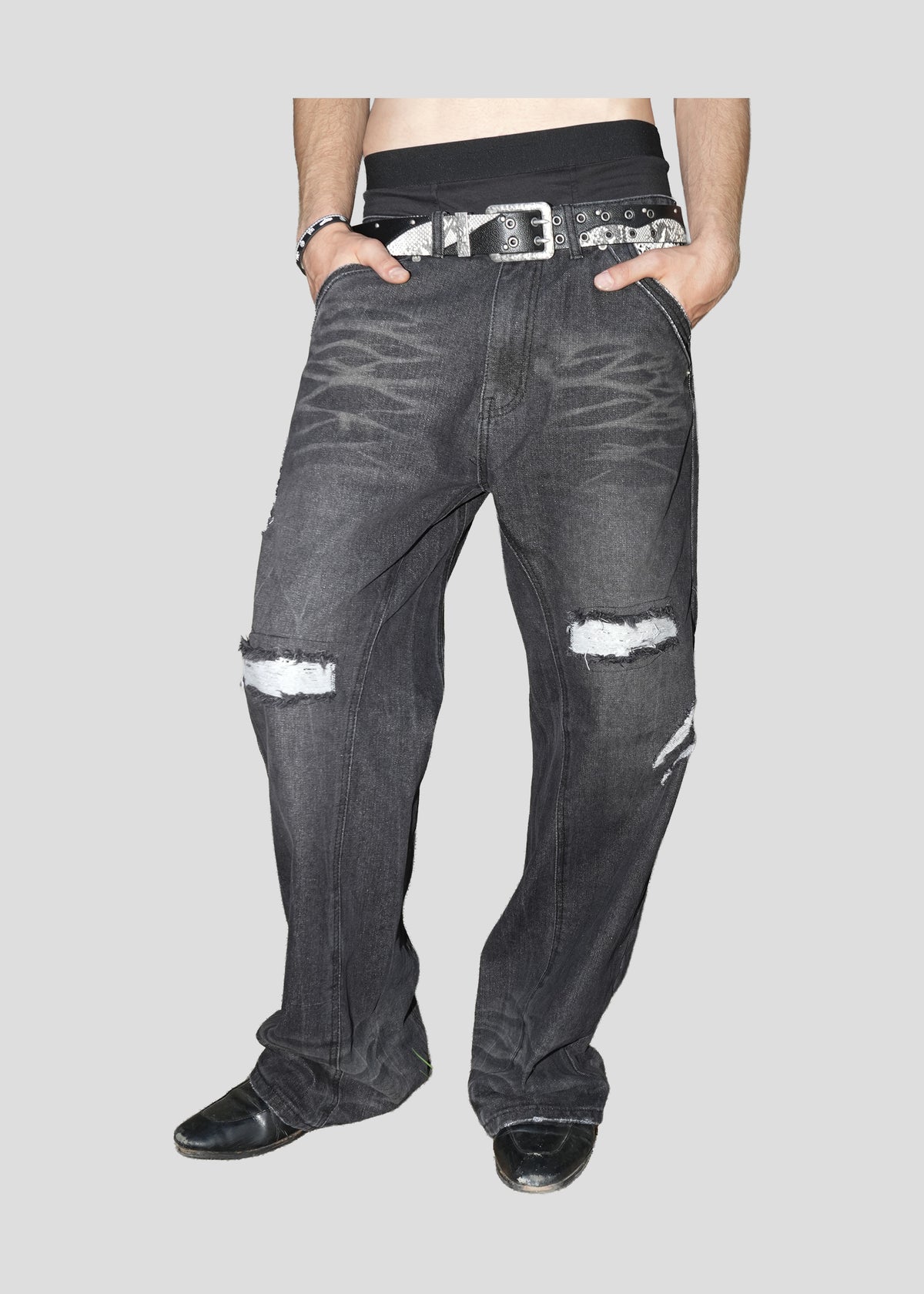 Model wearing ONEFATE Snake Jeans with a studded snake-pattern belt, front view from the waist down