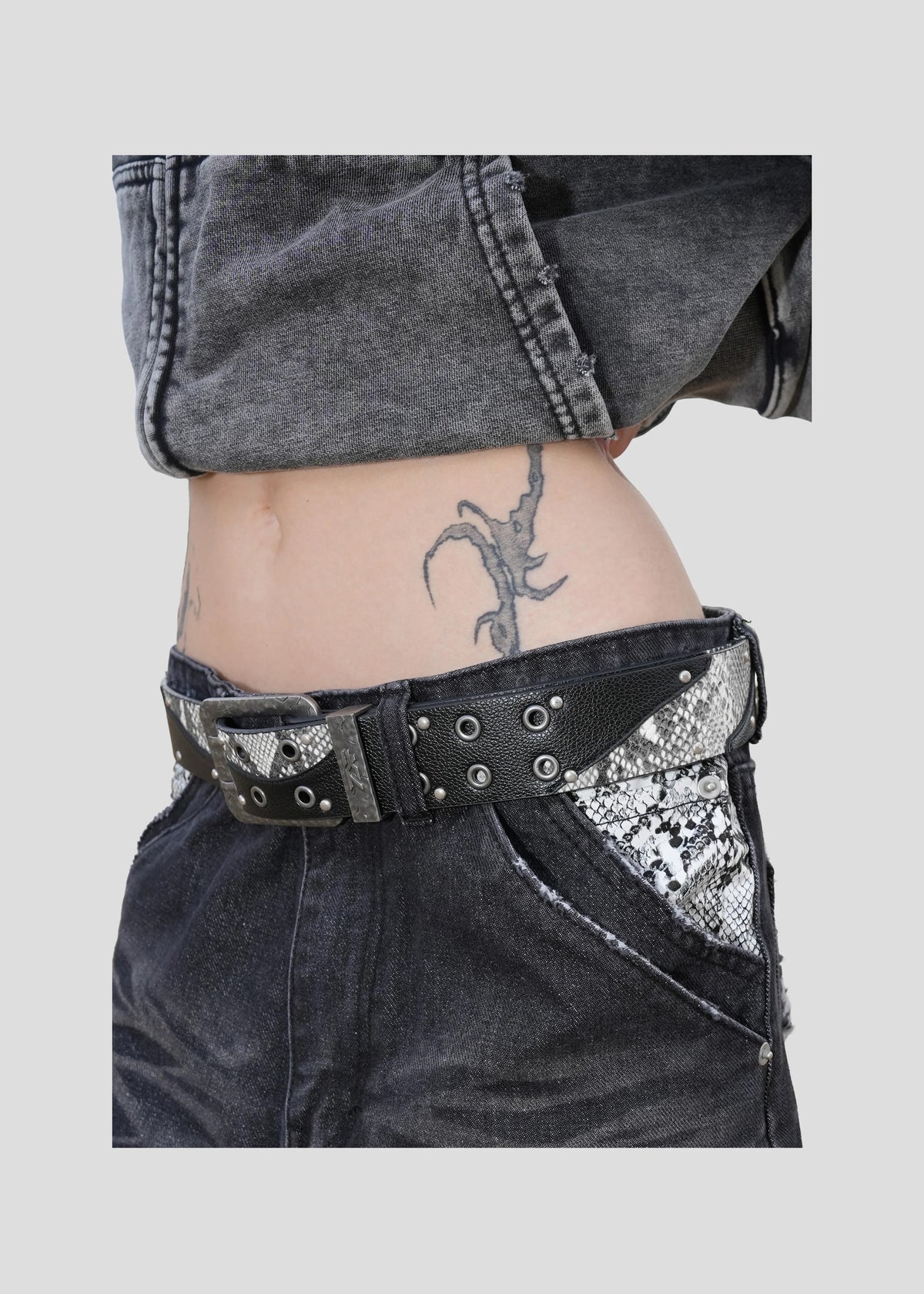 Model wearing the ONEFATE Snake Belt at the hip, side view, with black Snake Jeans