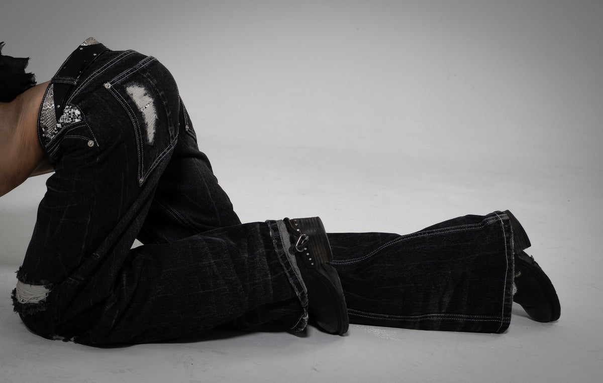 ONEFATE Campaign 01 – black snake denim with snake-pattern panels, model lying on the studio floor
